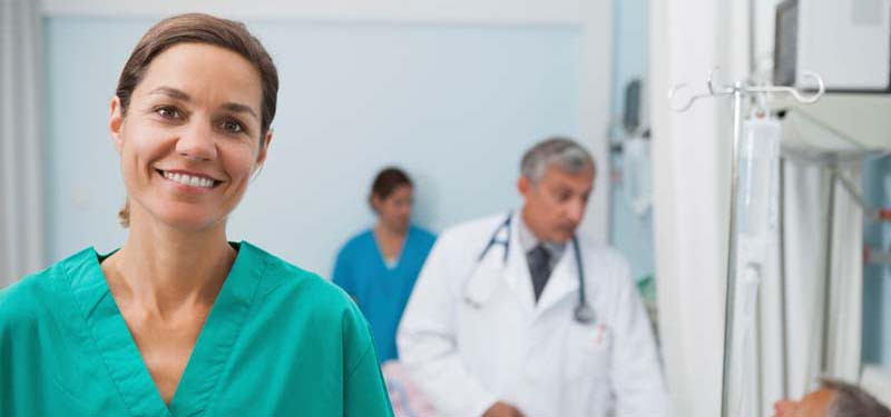 Nurse in Hospital Room Smiling at Camera